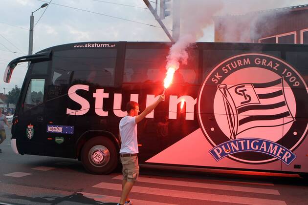 FUSSBALL - UEFA CL Quali, GRAZ,AUSTRIA,03.AUG.11 - FUSSBALL - UEFA Champions League, Qualifikation, SK Sturm Graz. Bild zeigt den Mannschaftsbus von Sturm und einen Fan. Keywords: Bengalisches Feuer, Rauch.
