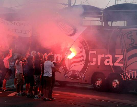 FUSSBALL - UEFA CL Quali, GRAZ,AUSTRIA,03.AUG.11 - FUSSBALL - UEFA Champions League, Qualifikation, SK Sturm Graz. Bild zeigt den Mannschaftsbus von Sturm und Fans. Keywords: Bengalisches Feuer, Rauch, Fahnen.