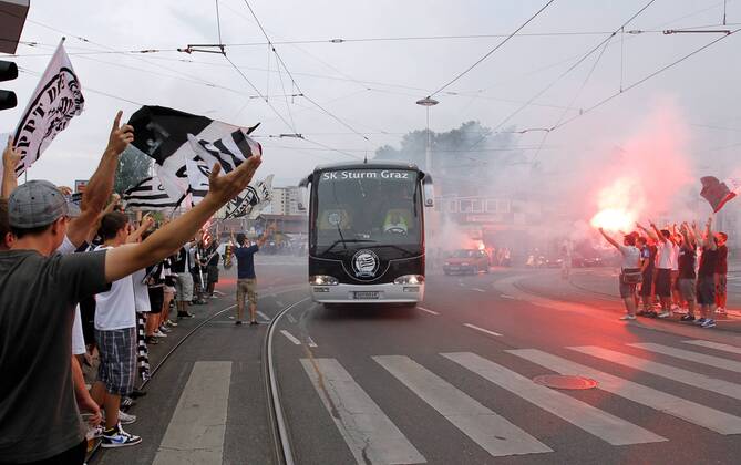 FUSSBALL - UEFA CL Quali, GRAZ,AUSTRIA,03.AUG.11 - FUSSBALL - UEFA Champions League, Qualifikation, SK Sturm Graz. Bild zeigt den Mannschaftsbus von Sturm und Fans. Keywords: Bengalisches Feuer, Rauch, Fahnen. o00 totale