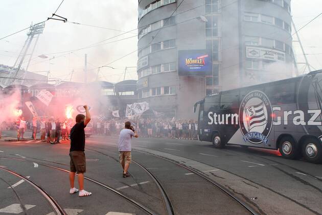 FUSSBALL - UEFA CL Quali, GRAZ,AUSTRIA,03.AUG.11 - FUSSBALL - UEFA Champions League, Qualifikation, SK Sturm Graz. Bild zeigt den Mannschaftsbus von Sturm und Fans. Keywords: Bengalisches Feuer, Rauch, Fahnen. o00 totale