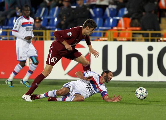 ITAR-TASS: KAZAN, RUSSIA. AUGUST 24, 2011. Russian FC Rubin Kazanâ€™s Solomon Kvirkvelia and French FC Lyonâ€™s Lisandro Lopez (front, L-R) struggle for the ball in their UEFA Champions League game at Central Stadium in the city of Kazan.  RE0ECA44