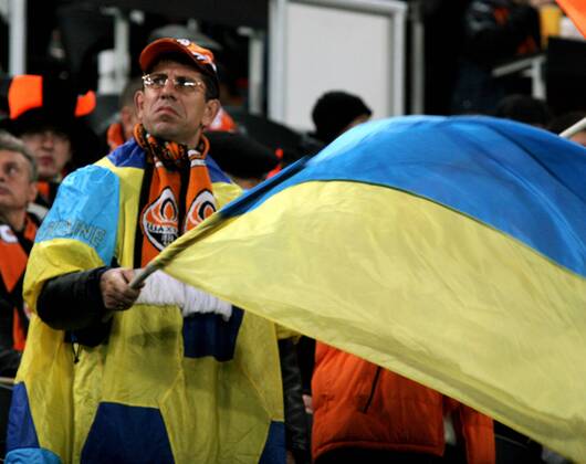 DONETSK. OCTOBER 20, 2011. Shakhtar Donetsk fan holding up Ukrain national flags during a UEFA Champions League Group G match between at Donbass Arena Stadium.  RE0F0625