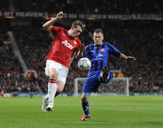 Phil Jones of Manchester United challenged by Silviu llie of Otelul Galati UEFA Champions League Group C Manchester United v CS Otelul Galati 2nd November, 2011 EDITORIAL USE ONLY. No use with unauthorised audio, video, data, fixture lists, club league logos or live services. Online in-match use limited to 120 images, no video emulation. No use in betting, games or single club league player publications.