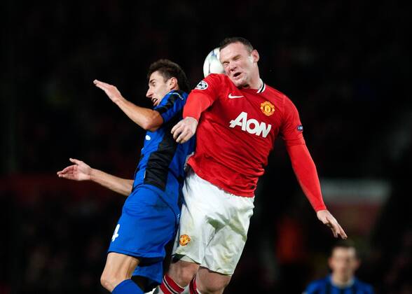 Wayne Rooney of Manchester United challenges Ioan Filip of Otelul Galati UEFA Champions League Group C Manchester United v CS Otelul Galati 2nd November, 2011 EDITORIAL USE ONLY. No use with unauthorised audio, video, data, fixture lists, club league logos or live services. Online in-match use limited to 120 images, no video emulation. No use in betting, games or single club league player publications.