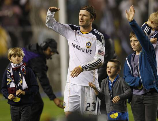 Los Angeles Galaxy midfielder David Beckham and his kids, Romeo, Cruz and Brooklyn wave to family up in the suites after the Galaxy beat the Houston Dynamo in the MLS Fussball Herren USA Cup at the Home Depot Center in Carson, California on Nov. 20, 2011. He was asking for someone to bring his baby to the field. The Galaxy won 1-0.  LAP20111120919