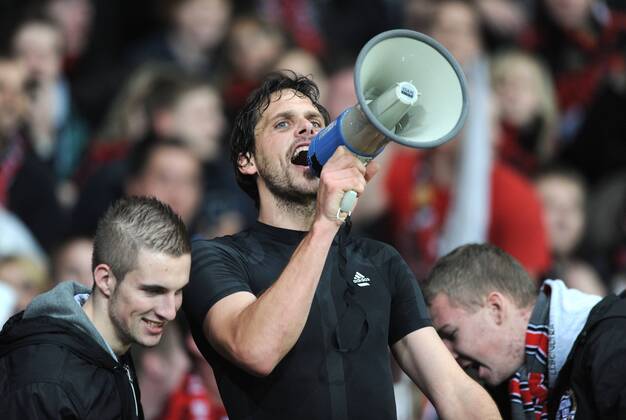 23-11-2011, Fussball, Saison 2011-2012, UEFA Champions League, Vorrunde, 5. Spieltag, BAYER 04 LEVERKUSEN, Manuel Friedrich (Bayer 04 Leverkusen) feiert in der Fankurve und mit Megafon den Sieg o0 Fan Objekte