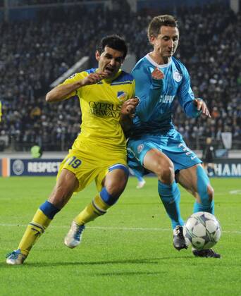 ITAR-TASS: ST PETERSBURG, RUSSIA. NOVEMBER 23, 2011. Apoelâ€™s Marios Elia (yellow), Zenitâ€™s Vladimir Bystrov (blue) in a 2011 2012 season UEFA Champions League Round 5, Group G match which ended in a 0-0 draw at the Petrovsky Stadium.  premiumd RE0F2CB0