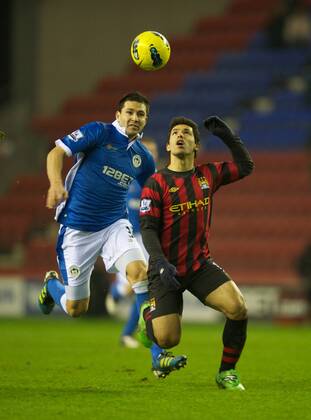 Manchester City s Sergio Kun Agüero in action against Wigan Athletic s Antolin Alcaraz during the Premiership match at the DW Stadium. xHOCHxZWEIx xPropagandax