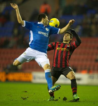 Manchester City s Sergio Kun Agüero in action against Wigan Athletic s Antolin Alcaraz during the Premiership match at the DW Stadium. xHOCHxZWEIx xPropagandax