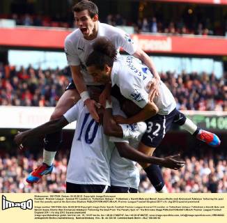 Football - Premier League - Arsenal FC London vs. Tottenham Hotspur - Tottenham s Gareth Bale and Benoit Assou-Ekotto mob Emmanuel Adebayor following his goal from the penalty spot at the Emirates Stadium
