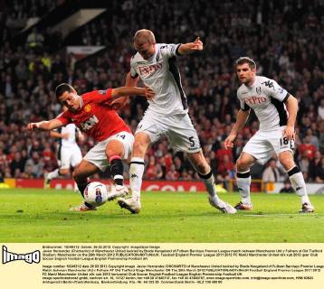 Javier Hernandez (Chicharito) of Manchester United tackled by Brede Hangeland of Fulham Barclays Premier League match between Manchester Utd v Fulham at Old Trafford Stadium, Manchester on the 26th March 2012 EDITORIAL USE ONLY. No use with unauthorised audio, video, data, fixture lists, club league logos or live services. Online in-match use limited to 120 images, no video emulation. No use in betting, games or single club league player publications.