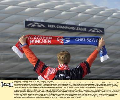 16..05.2012, Fussball Champions-League Finale 2012, Ein Bayernfan steht vor dem Stadion (Allianz-Arena) in München in dem das Finale zwischen FC Bayern München und FC Chelsea London stattfindet und schwenkt den Final-Schal mit Logos der beiden Mannschaften.