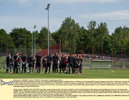 Die Mannschaft steht gemeinsam auf dem Trainingsplatz unter Beobachtung von Bayern Fans im Hintergrund. Fussball UEFA Championsleague Finale 2012 - Offizielles Training des FC Bayern München zum Finalspiel in München, Deutschland am 18.05.2012,