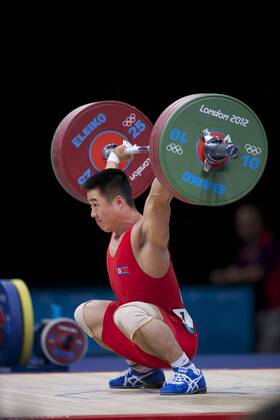 July 31, 2012 - London, England, United Kingdom - KIM UN GUK (PRK) competes in the men s 62kg clean and jerk weightlifting competition at ExCeL in London. Guk won an Olympic goldmedal and set an Olympic record in the the snatch competition with a lift of 153kg. Olympics 2012 - Weightlifting - ZUMAw10