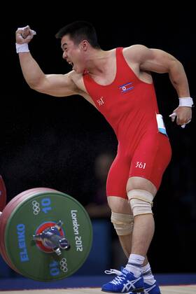 July 31, 2012 - London, England, United Kingdom - KIM UN GUK (PRK) celebrates completing a lift in the men s 62kg weightlifting competition at ExCeL in London. Guk won an Olympic goldmedal and set an Olympic record in the the snatch competition with a lift of 153kg. Olympics 2012 - Weightlifting - ZUMAw10