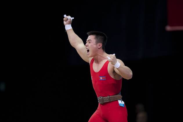 July 31, 2012 - London, England, United Kingdom - KIM UN GUK (PRK) celebrates completing a lift in the men s 62kg weightlifting competition at ExCeL in London. Guk won an Olympic goldmedal and set an Olympic record in the the snatch competition with a lift of 153kg. Olympics 2012 - Weightlifting - ZUMAw10