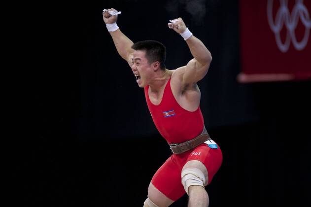 July 31, 2012 - London, England, United Kingdom - KIM UN GUK (PRK) celebrates completing a lift in the men s 62kg weightlifting competition at ExCeL in London. Guk won an Olympic goldmedal and set an Olympic record in the the snatch competition with a lift of 153kg. Olympics 2012 - Weightlifting - ZUMAw10
