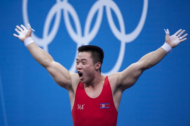 July 31, 2012 - London, England, United Kingdom - KIM UN GUK (PRK) celebrates completing a lift in the men s 62kg weightlifting competition at ExCeL in London. Guk won an Olympic goldmedal and set an Olympic record in the the snatch competition with a lift of 153kg. Olympics 2012 - Weightlifting - ZUMAw10