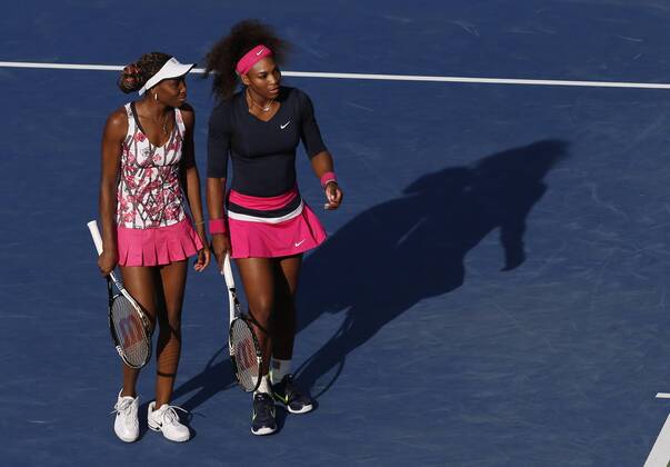 Venus and Serena Williams talk in between points in their doubles match in Arthur Ashe Stadium at the BillieJean King National Tennis Center in New York City on August 31, 2012.  NYP20120831146