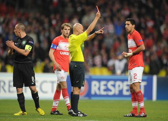 ITAR-TASS: MOSCOW, RUSSIA. OCTOBER 2, 2012. Referee Tony Chapron (C) gives Spartak Moscow s Juan Insaurralde (R) a red card as his teammate Dmitry Kombarov (L in red) looks on in their UEFA Champions League Group G football match against Celtic F.C. at Luzhniki Stadium. Back (L-R): Spartak s Rafael Carioca and goalkeeper Sergei Pesyakov. Celtic F.C. won the game 2-3. Left: Celtic s Scott Brown.  premiumd RE109CDE