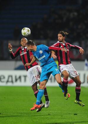 ITAR-TASS: ST PETERSBURG, RUSSIA. OCTOBER 3, 2012. Zenit s Vladimir Bystrov (C) and Milan s Nigel de Jong (L) and Luca Antonini jump to head the ball in their UEFA Champions League Group C football match at Petrovsky Stadium. A.C. Milan won the game 2-3.  premiumd 209084