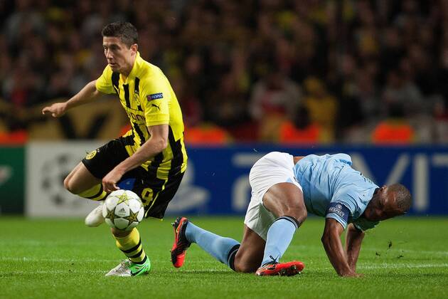 Football - Champions League - Manchester City vs. Borussia Dortmund Robert Lewandowski of Dortmund escapes Vincent Kompany of Manchester City at the Etihad Stadium 