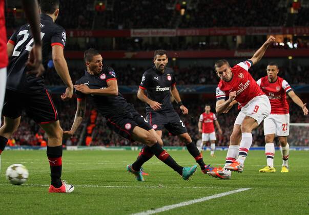 Arsenal s Lukas Podolski scoring his sides second goal..Football - Champions League Matchday 2 - Emirates Stadium, London - 3 10 12EDITORIAL USE ONLY. EDITORIAL USE ONLY. No use with unauthorised audio, video, data, fixture lists, club league logos or live services. Online in-match use limited to 120 images, no video emulation. No use in betting, games or single club league player publications.
