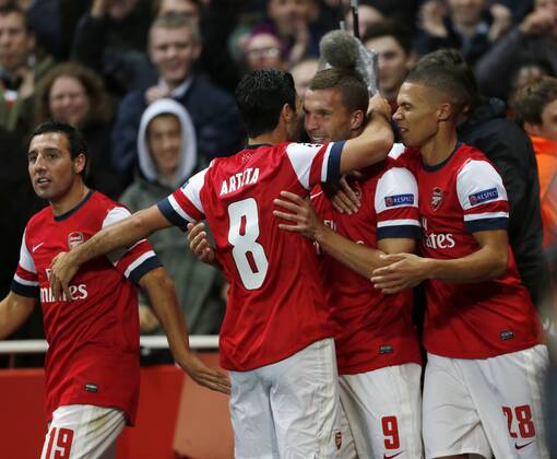 Arsenal s Lukas Podolski celebrates scoring his sides second goal..Football - Champions League Matchday 2 - Emirates Stadium, London - 3 10 12EDITORIAL USE ONLY. EDITORIAL USE ONLY. No use with unauthorised audio, video, data, fixture lists, club league logos or live services. Online in-match use limited to 120 images, no video emulation. No use in betting, games or single club league player publications.