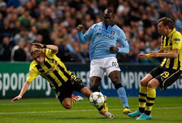 Manchester City s Mario Balotelli (C) in action with Borussia Dortmund s Marcel Schmelzer (L)..Champions League football match between Manchester City and Borussia Dortmund at the Etihad Stadium, Manchester on the 3rd October 2012 EDITORIAL USE ONLY. No use with unauthorised audio, video, data, fixture lists, club league logos or live services. Online in-match use limited to 120 images, no video emulation. No use in betting, games or single club league player publications.