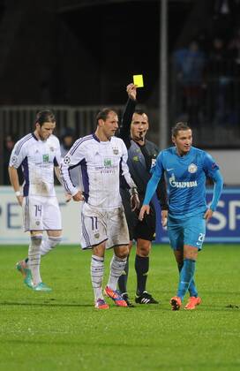 ST. PETERSBURG, RUSSIA. OCTOBER 24, 2012. RSC Anderlecht s Bram Nuytinck, Cheikhou Kouyate, referee Ivan Bebek and FC Zenit s Viktor Fayzulin (L-R) in a UEFA Champions League game in St Petersburg.  RE10BA4B
