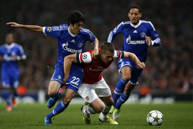 (121025) -- LONDON, Oct. 25, 2012(Xinhua) -- Lukas Podolski (C) of Arsenal vies with Atsuto Uchida (L) of Schalke 04 during the UEFA Champions League Group B match between Arsenal and FC Schalke 04 at the Emirates Stadium in London, Britain on October 24, 2012. FC Schalke 04 won 2-0. (Xinhua Wang Lili) BRITAIN-LONDON-SOCCER-UEFA-CHAMPIONS LEAGUE-ARSENAL-SCHALKE 