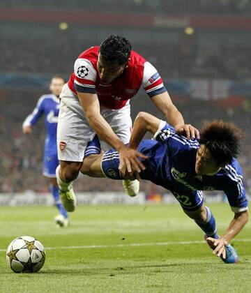 (121025) -- LONDON, Oct. 25, 2012(Xinhua) --Andr¨¦ Santos (Top) of Arsenal vies with Atsuto Uchida of Schalke 04 during the UEFA Champions League Group B match between Arsenal and FC Schalke 04 at the Emirates Stadium in London, Britain on October 24, 2012.FC Schalke 04 won 2-0. (Xinhua Wang Lili) BRITAIN-LONDON-SOCCER-UEFA-CHAMPIONS LEAGUE-ARSENAL-SCHALKE 