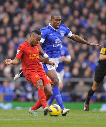 Raheem Sterling of Liverpool tussles with Sylvain Distin of Everton - Barclays Premier League - Everton vs Liverpool - Goodison Park Stadium - Liverpool - 28 10 12 - Picture Simon Bellis Sportimage EDITORIAL USE ONLY. No use with unauthorised audio, video, data, fixture lists, club league logos or live services. Online in-match use limited to 120 images, no video emulation. No use in betting, games or single club league player publications.