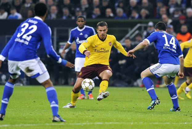 Fussball, UEFA Champions League, Herren, Saison 2012 2013, 4. Spieltag, Gruppe B, Veltins-Arena Gelsenkirchen, FC Schalke 04 (blau) - Arsenal London (gelb) 2:2; v.li.: Joel Matip (S04), Jefferson Farfan (S04), Lukas Podolski (Arsenal), Kyriakos Papadopoulos (S04), Aktion.