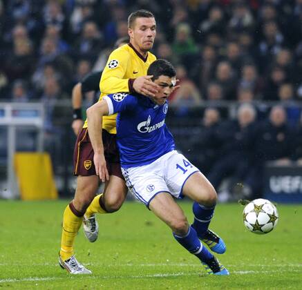 Fussball, UEFA Champions League, Herren, Saison 2012 2013, 4. Spieltag, Gruppe B, Veltins-Arena Gelsenkirchen, FC Schalke 04 (blau) - Arsenal London (gelb) 2:2; Kyriakos Papadopoulos (S04), Lukas Podolski (Arsenal), Aktion.