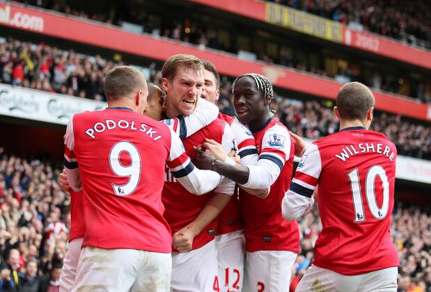 Arsenal s Per Mertesacker celebrates with goalscorer Lukas Podolski ..Arsenal FC London v Tottenham Hotspur - Premier League- Emirates Stadium, London- 17 11 12 - EDITORIAL USE ONLY. No use with unauthorised audio, video, data, fixture lists, club league logos or live services. Online in-match use limited to 120 images, no video emulation. No use in betting, games or single club league player publications.