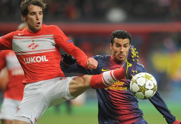 ITAR-TASS: MOSCOW, RUSSIA. NOVEMBER 20, 2012. Spartak s Dmitry Kombarov kicks (L) the ball as Barcelona s Pedro Rodriguez looks on in a UEFA Champions League Group G football match at Luzhniki Stadium.  RE10DE8E