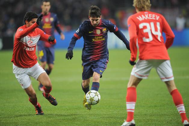 ITAR-TASS: MOSCOW, RUSSIA. NOVEMBER 20, 2012. Barcelona s Lionel Messi (C) runs with the ball under pressure from Spartak s Juan Insaurralde (L) and Yevgeny Makeyev (34) in a UEFA Champions League Group G football match at Luzhniki Stadium.  RE10DE93