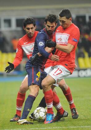 ITAR-TASS: MOSCOW, RUSSIA. NOVEMBER 20, 2012. Barcelona s Cesc Fabregas (C) gets squeezed between Spartak s Juan Insaurralde (L) and Marek Suchy in a UEFA Champions League Group G football match at Luzhniki Stadium.  RE10DE9C
