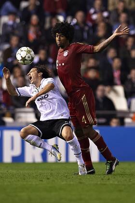 VALENCIA, SPAIN - NOVEMBER 20: (L) Andres Guardado of Valencia being fouled by (R) Dante of Bayern Munich during the UEFA Champions League between Valencia CF and FC Bayern Munich at the Mestalla Stadium on November 20, 2012 in Valencia, Spain. (Photo by Aitor Alcalde Colomer) 