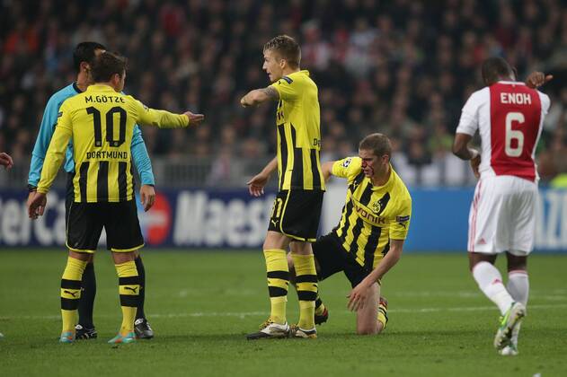 21.11.2012 Fussball Champions League Vorrunde 5. Spieltag Gruppe D AJAX Amsterdam - BVB Borussia Dortmund Fussball Maenner Saison 2012 13 Sven BENDER (Borussia Dortmund - BVB - 6) blutüberströmt - Marco REUS (Borussia Dortmund - BVB - 11) und Mario GÖTZE (Borussia Dortmund - BVB - 10) zeigen es an Eyong ENOH (AJAX Amsterdam - 6) hat den Ellbogen ausgefahren