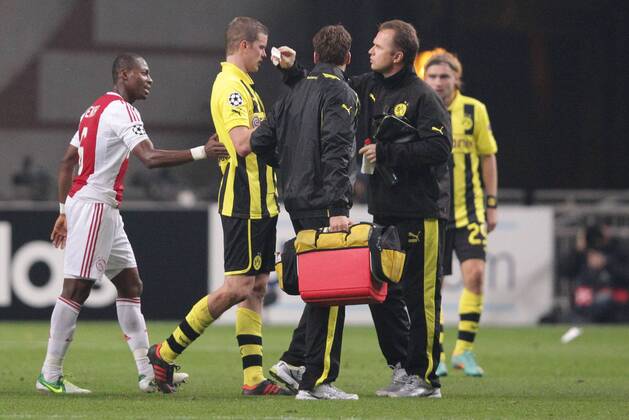 Verletzung Sven BENDER (Borussia Dortmund - BVB - 6) - Nase blutet - wird von Mannschaftsarzt verpflegt Eyong ENOH (AJAX Amsterdam - 6) erkundigt sich nach ihm 21.11.2012 Fussball Champions League Vorrunde 5. Spieltag Gruppe D AJAX Amsterdam - BVB Borussia Dortmund Fussball Maenner Saison 2012 13