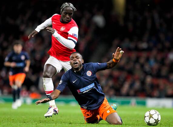 Bacary Sagna (L) of Arsenal vies with Henri Bedimo of Montpellier during the UEFA Champions League Group B match between Arsenal and Montpellier in London, Britain, Nov. 21, 2012. Arsenal won 2-0. (Xinhua Tang Shi) (jyc) FC ARSENAL LONDON VS MONTPELLIER HSC - 
