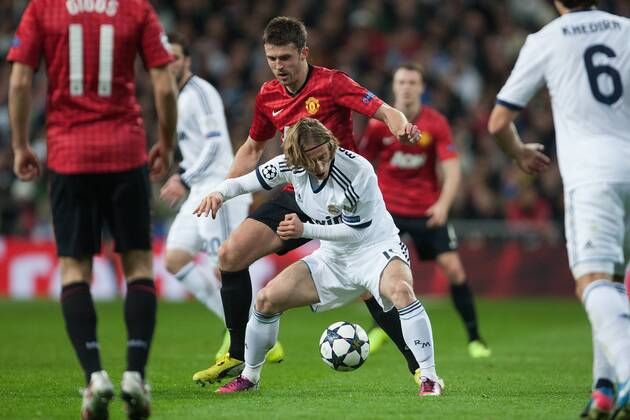 Football - 2012 2013 Champions League - Round of 16, First Leg: Real Madrid vs. Manchester United Michael Carrick of Manchester United fends off Luka Modric of Real Madrid at the Santiago Bernabeu 