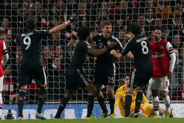 Football - 2012 2013 Champions League - Round of 16, First Leg: Arsenal vs. Bayern Munich Bayern Munich s Thomas Müller celebrates scoring while a dejected Mikel Arteta of Arsenal (right) at the Emirates Stadium, London 