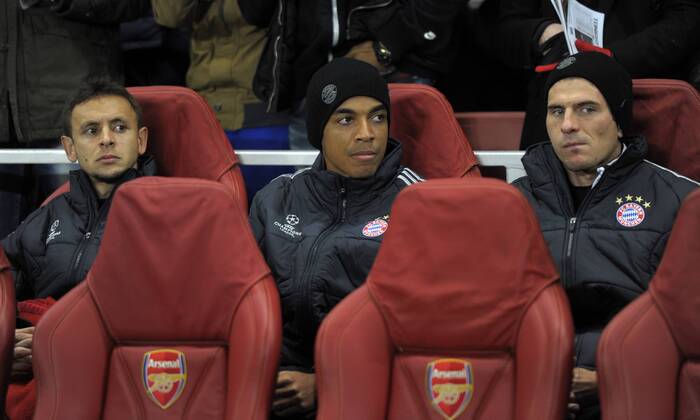 19.02.2013, Fussball Champions League: FC Arsenal London - FC Bayern München, im Emirates-Stadion London. v.li: Rafinha (Bayern), Luiz Gustavo (München) und Mario Gomez (München) auf der Ersatzbank.