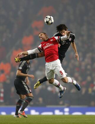 Arsenal s Lukas Podolski tussles with Munich s Javi Martinez..Arsenal v Bayern Munich - Champions League Second Round, First Leg- Emirates Stadium, London- 19 02 13 - Picture David Klein Sportimage EDITORIAL USE ONLY. No use with unauthorised audio, video, data, fixture lists, club league logos or live services. Online in-match use limited to 120 images, no video emulation. No use in betting, games or single club league player publications.