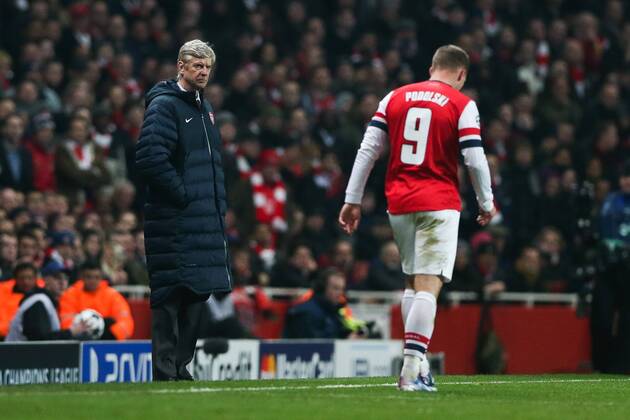 Football - 2012 2013 Champions League - Round of 16, First Leg: Arsenal vs. Bayern Munich Manager of Arsenal Arsene Wenger looks on as Lukas Podolski of Arsenal passes him with his head down at the Emirates Stadium, London