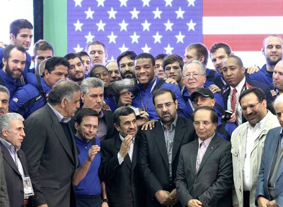 Iranian president Mahmoud Ahmadinejad (below C) stands beside members of the USA s freestyle wrestling team at the awarding ceremony of the Wrestling World Cup 2013 in Tehran, Iran, on Feb. 22, 2013. The team of the United States took the third place. (Xinhua Ahmad Halabisaz) IRAN-TEHRAN-WRESTLING-WORLD CUP 2013 