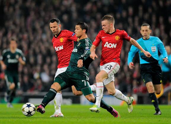 Cristiano Ronaldo of Real Madrid (c) gets between Ryan Giggs and Tom Cleverley of Manchester United - UEFA CHAMPIONS LEAGUE - ROUND OF 16 - Manchester Utd vs Real Madrid - Old Trafford Stadium - Manchester - 05 03 13 - Picture Simon Bellis Sportimage- EDITORIAL USE ONLY. No use with unauthorised audio, video, data, fixture lists, club league logos or live services. Online in-match use limited to 120 images, no video emulation. No use in betting, games or single club league player publications.